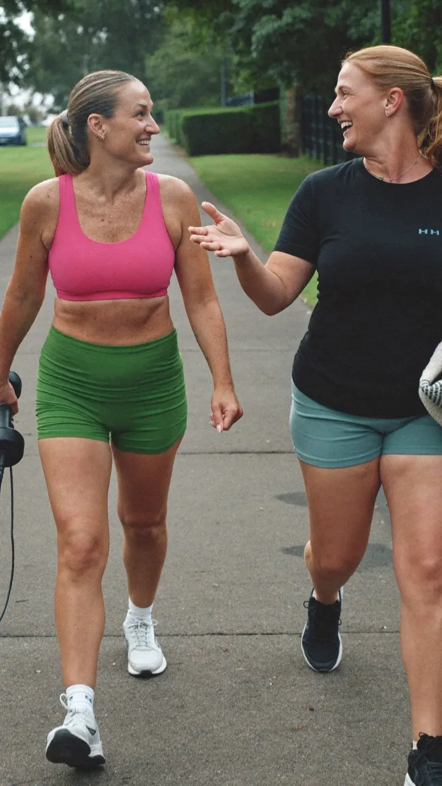 Two women in pink and green walking outdoors
