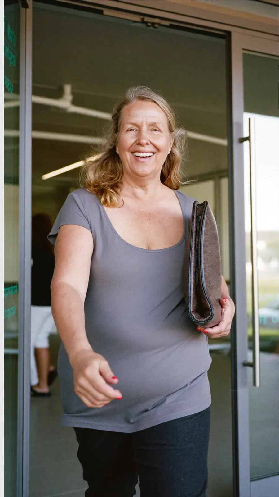 Woman smiling at a glass door